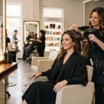 Woman in a salon chair with a stylist — how to choose a haircut before the salon